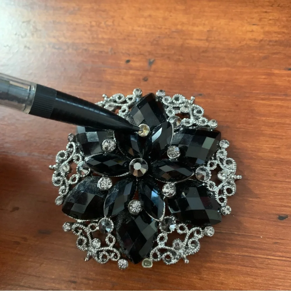Black rhinestones flower brooch with silver tone filigree